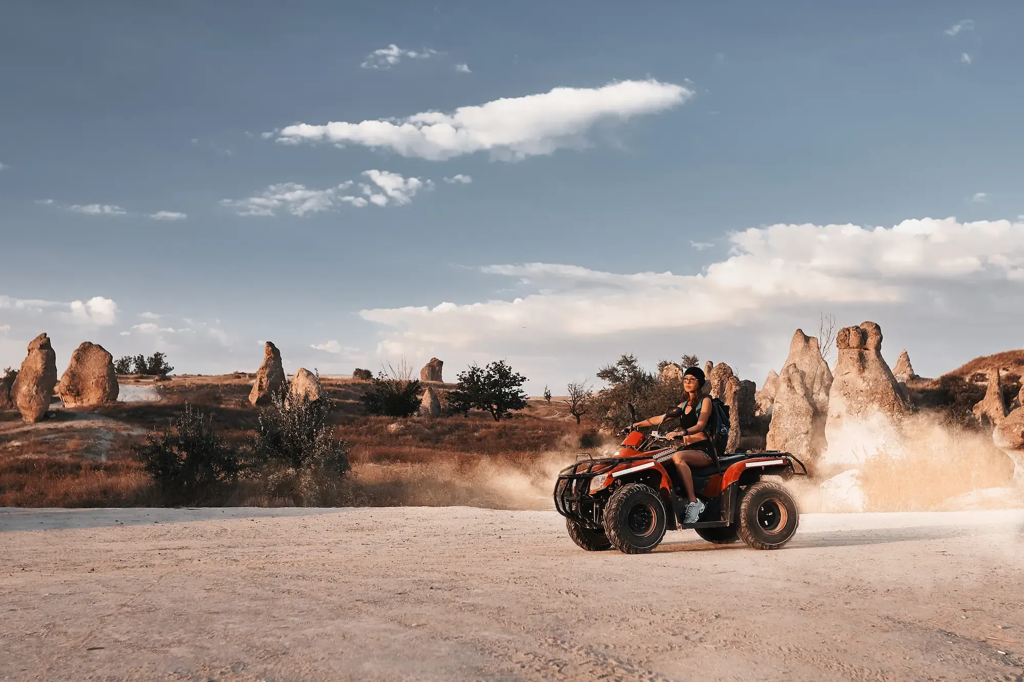 A woman driving an atv in the desert.