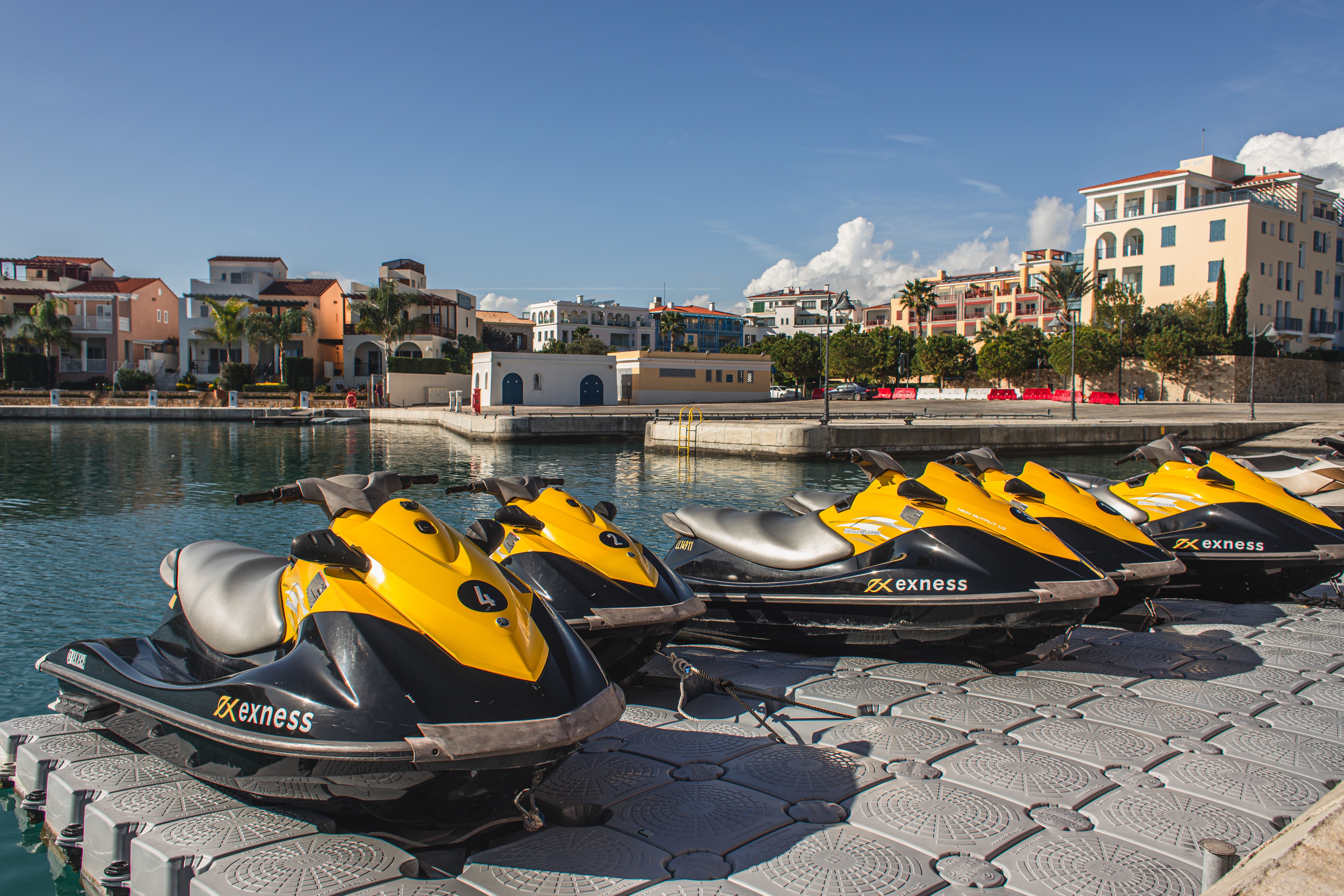 Jet skis parked outside by water.