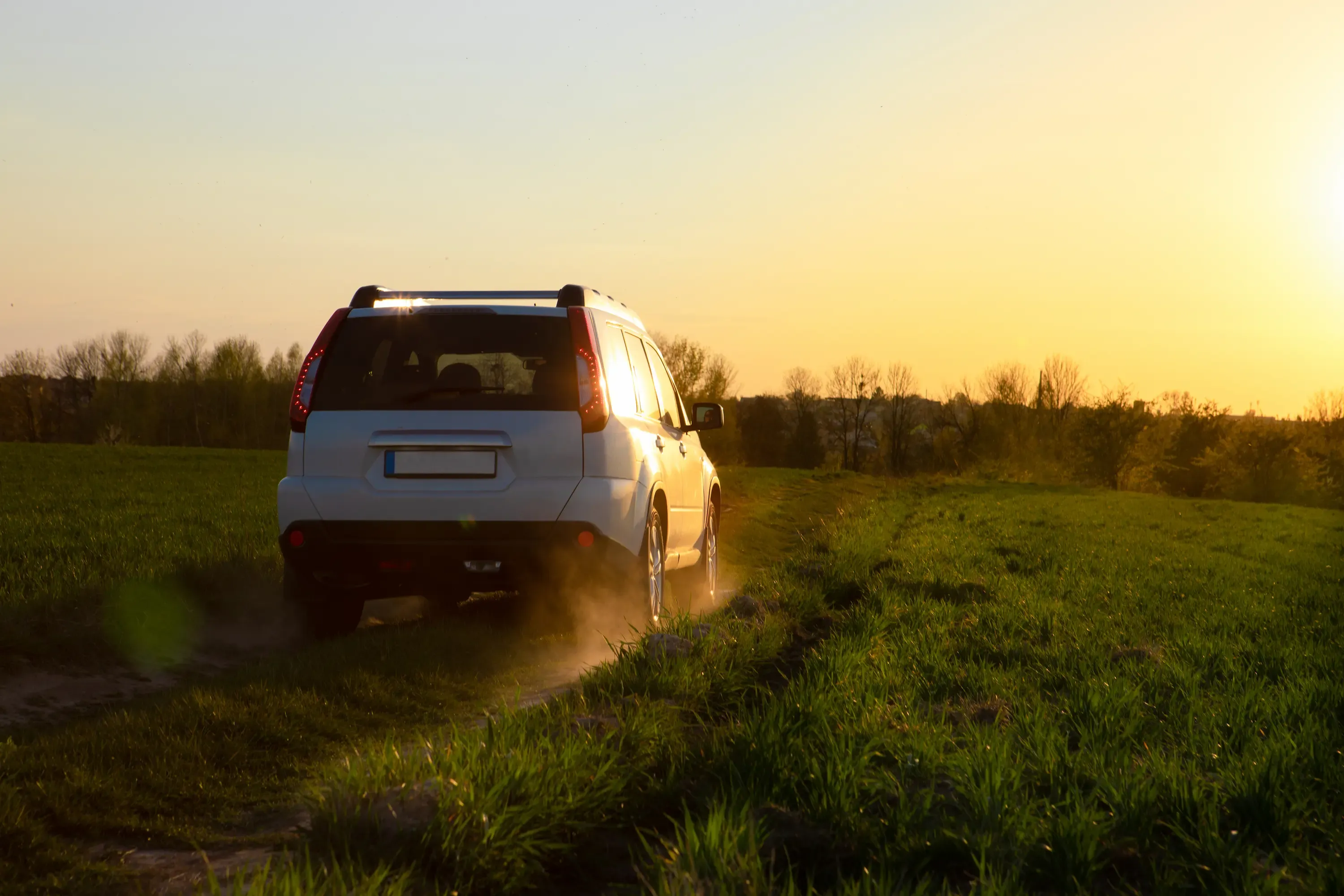 Suv driving during a sunset.
